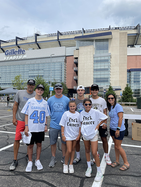 Group picture of recipients of the Dyin 2 Live Dreams program in front of the Gillette Stadium.